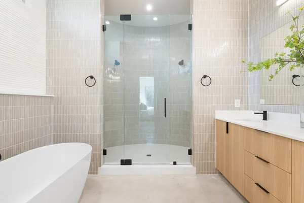 a bathroom with a tub shower sink and mirror