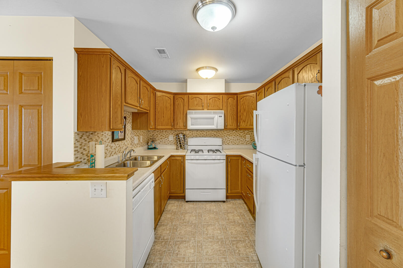 2007 West 75th Place, Unit 31 Merrillville, IN 46410 - Photo 9 of 17 a kitchen with a refrigerator a sink and dishwasher
