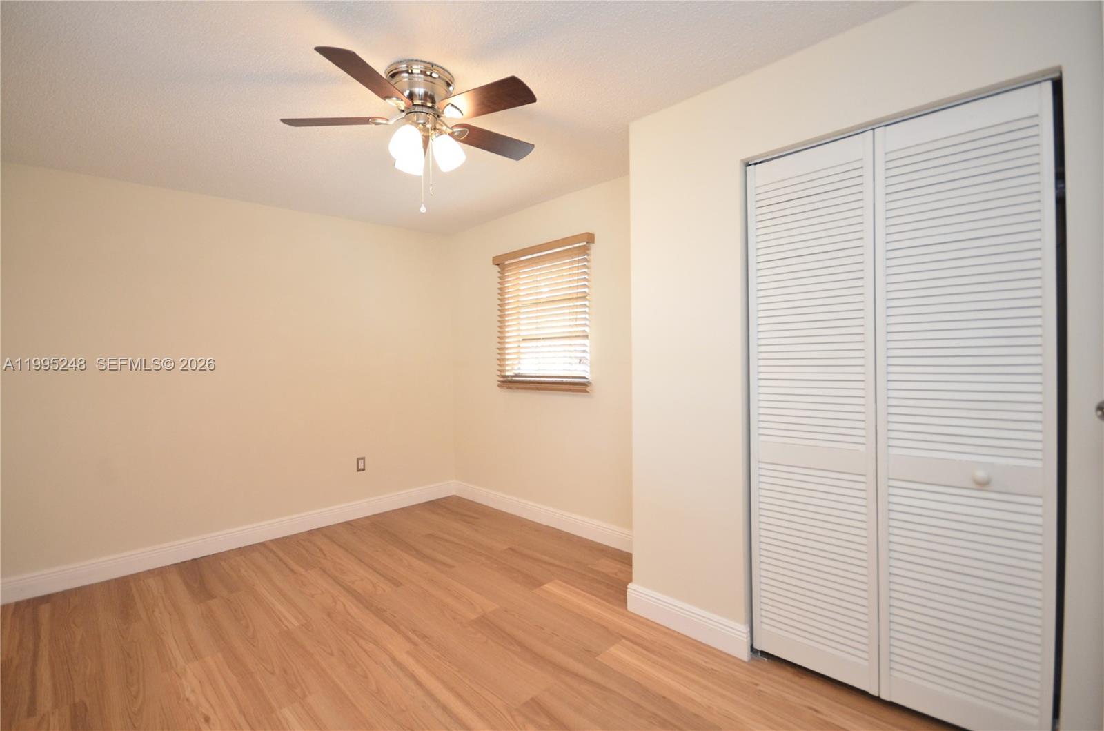 2430 Southwest 16th Street, Unit 2430 Miami, FL 33145 - Photo 11 of 18 an empty room with wooden floor and ceiling fan