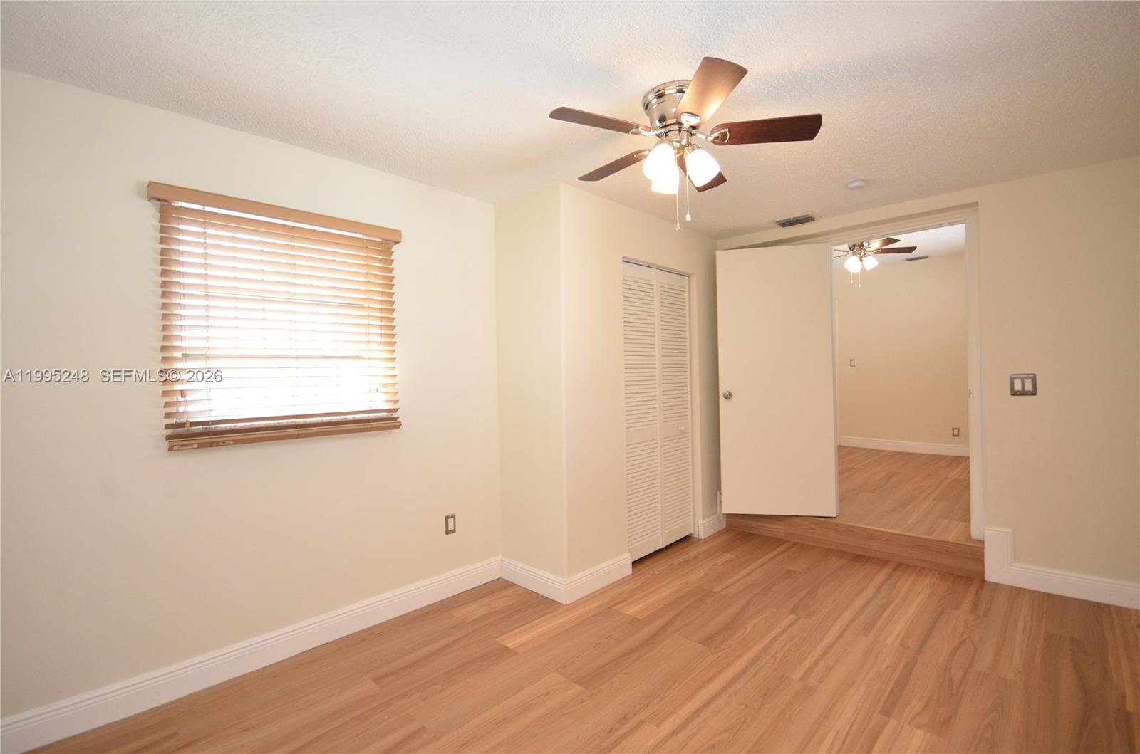 2430 Southwest 16th Street, Unit 2430 Miami, FL 33145 - Photo 12 of 18 a view of an empty room with wooden floor and a window