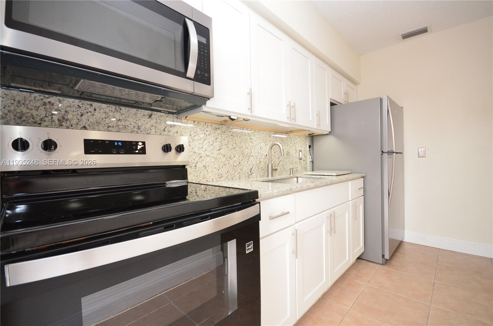 2430 Southwest 16th Street, Unit 2430 Miami, FL 33145 - Photo 4 of 18 a kitchen with stainless steel appliances a stove and a refrigerator