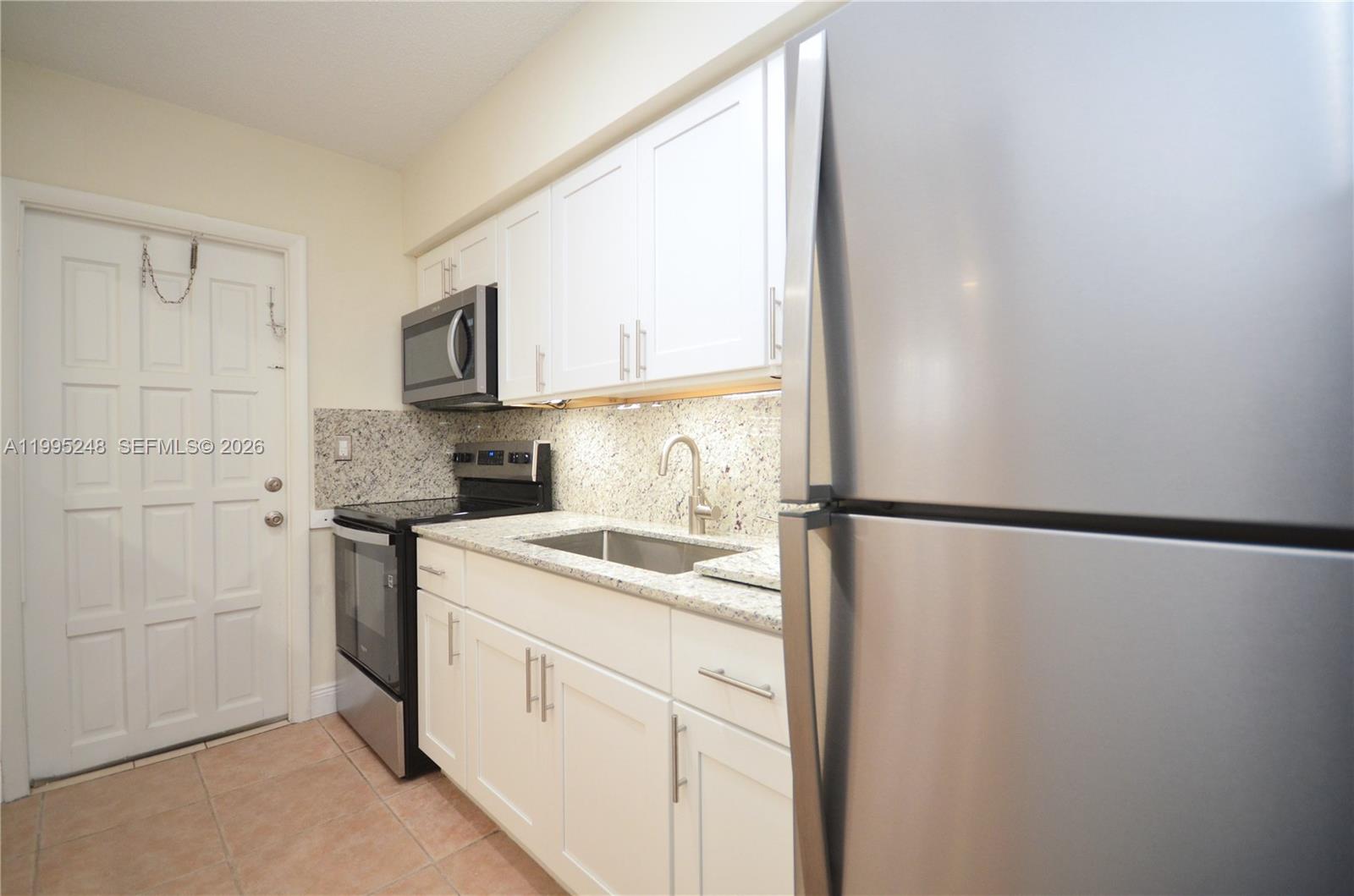 2430 Southwest 16th Street, Unit 2430 Miami, FL 33145 - Photo 5 of 18 a kitchen with a sink a refrigerator and a window