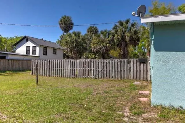 a view of a house with a small yard and wooden fence