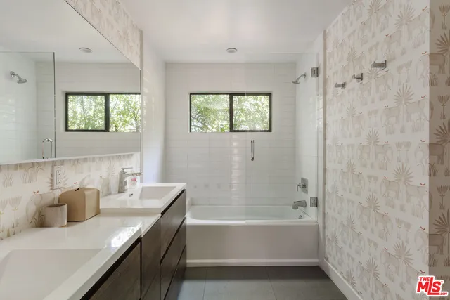 a bathroom with a granite countertop sink a bathtub and shower