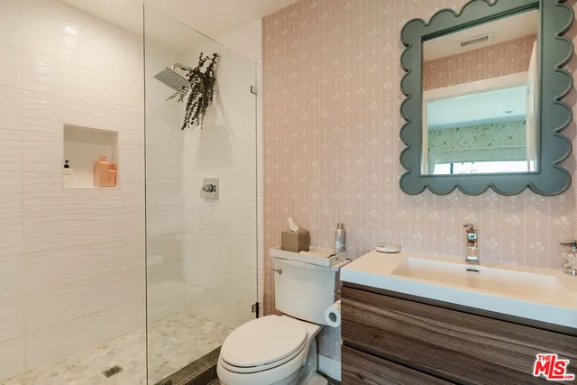 a bathroom with a sink a toilet and shower