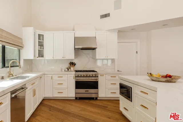 a kitchen with stainless steel appliances white cabinets and a stove