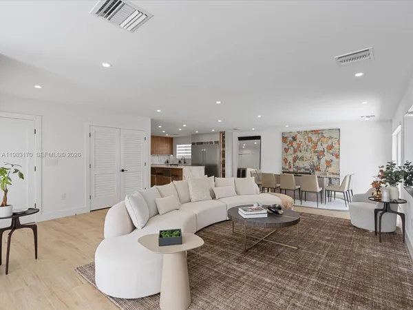 a living room with furniture and kitchen view