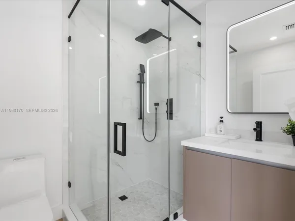 a bathroom with a shower sink and mirror