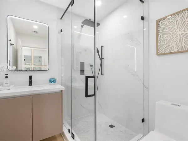 a bathroom with a shower sink and mirror