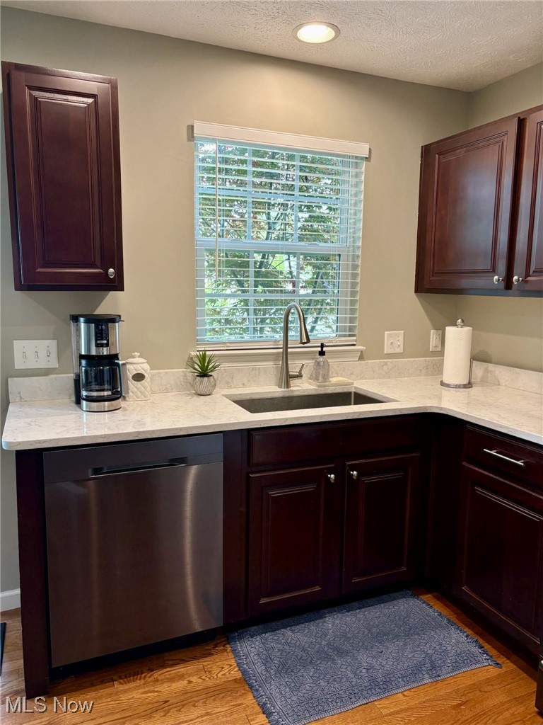 4156 Whitestone Road Kent, OH 44240 - Photo 6 of 28 Kitchen featuring stainless steel dishwasher, a sink, light wood finished floors, a textured ceiling, and light stone counters