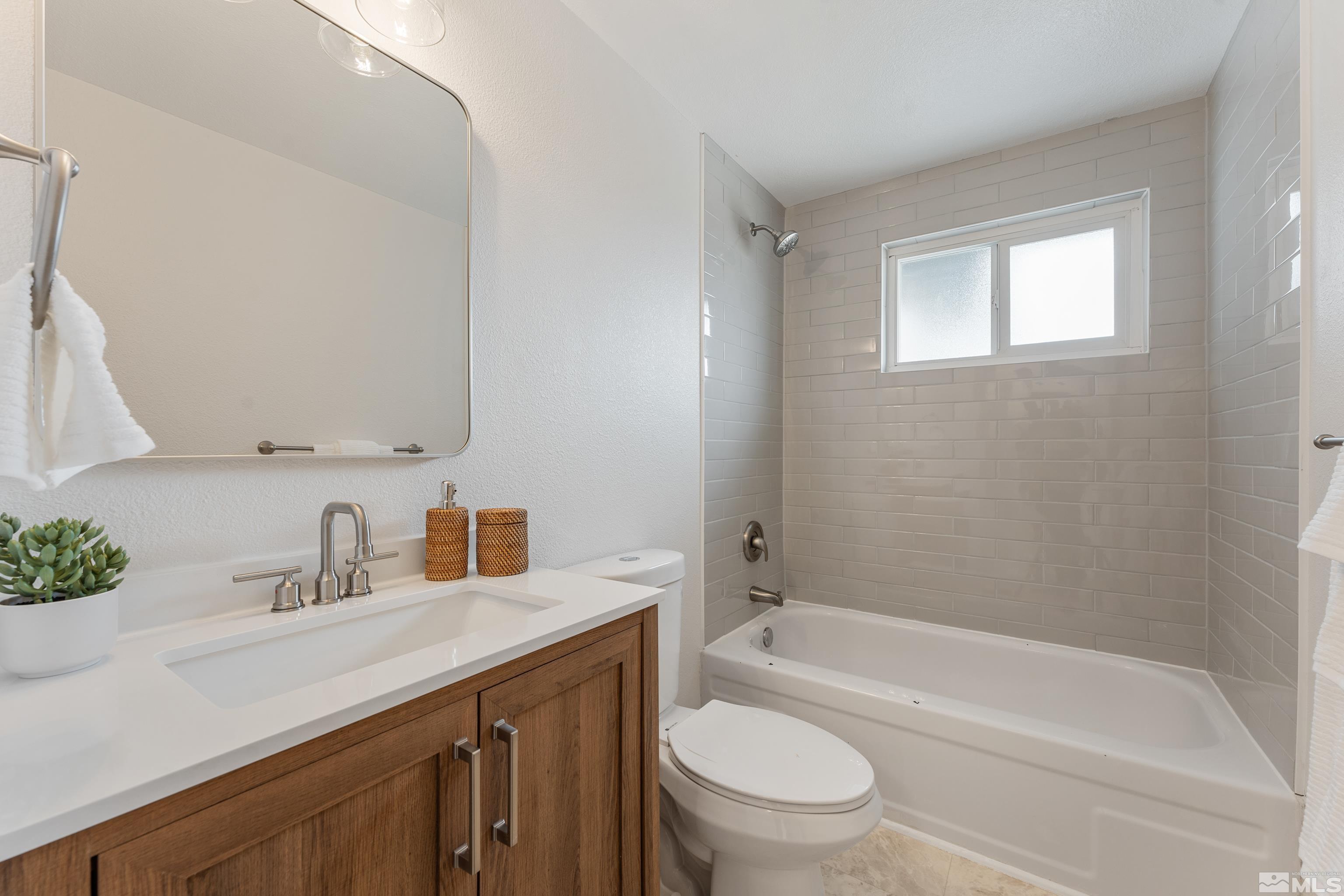 9495 Fremont Way Reno, NV 89506 - Photo 14 of 17 a bathroom with a sink a toilet a mirror a bathtub and shower
