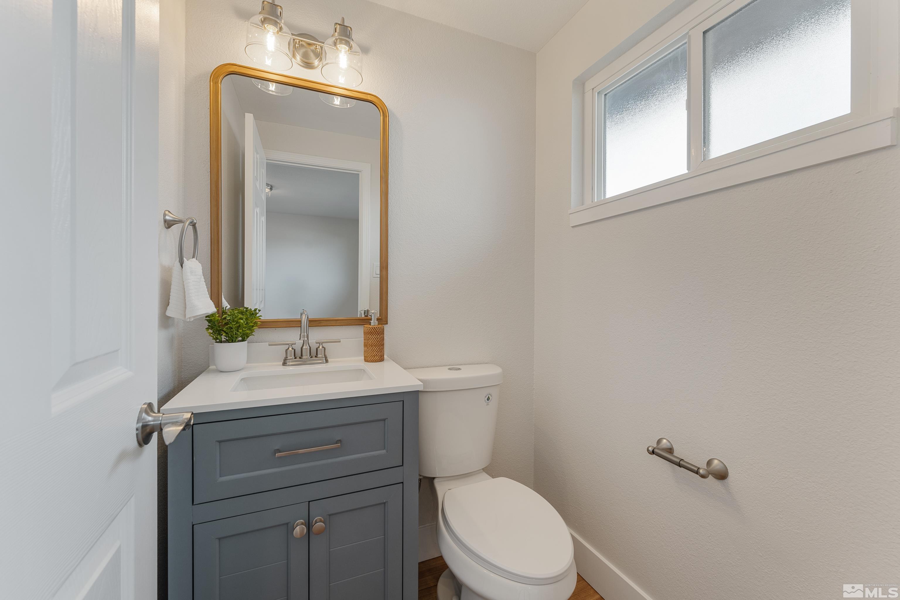 9495 Fremont Way Reno, NV 89506 - Photo 6 of 17 a bathroom with a toilet a sink a vanity and mirror