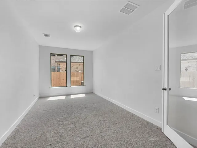 an empty room with windows and closet