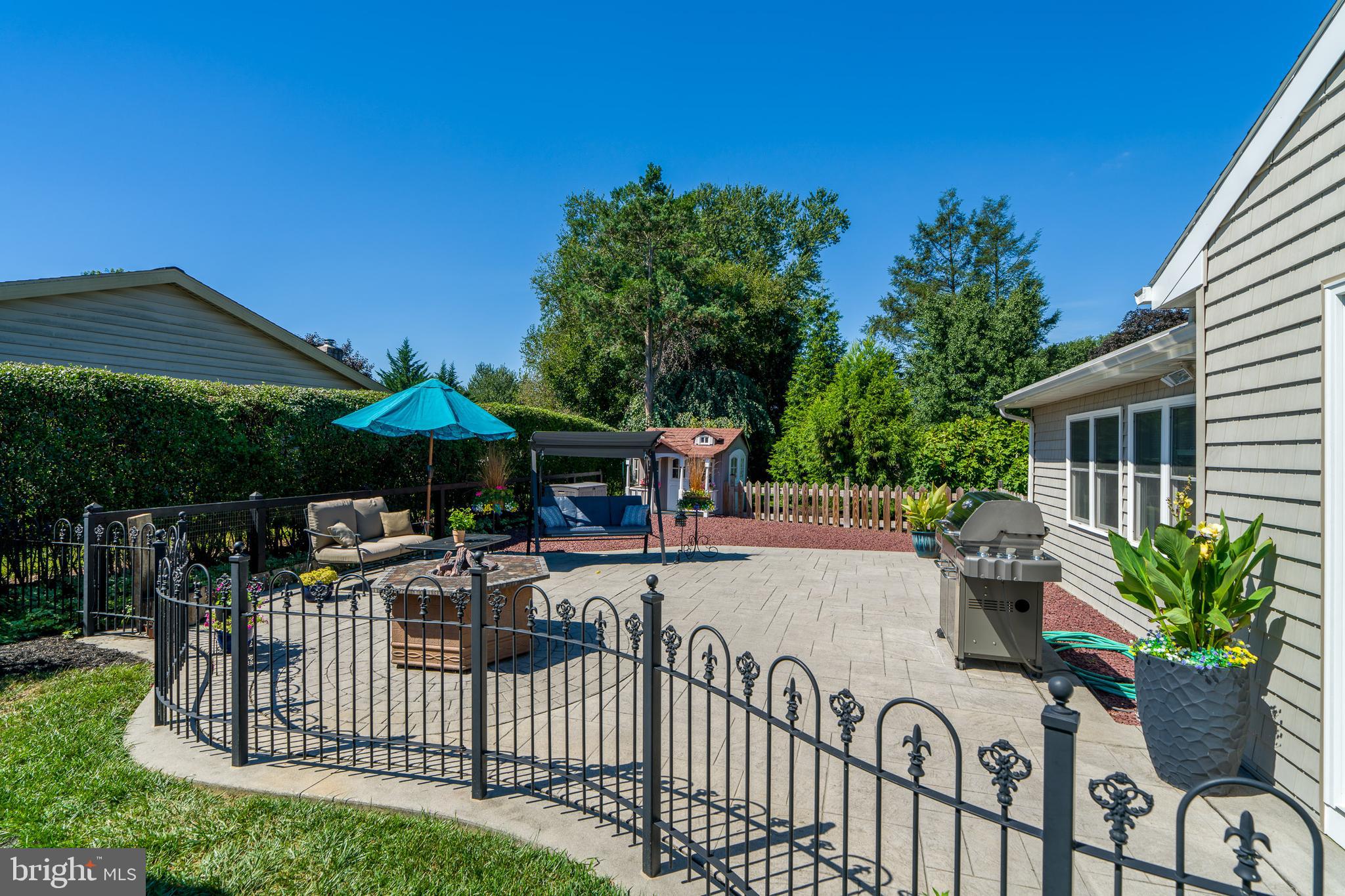 510 Bluebird Road Lititz, PA 17543 - Photo 25 of 32 a view of a patio with couches table and chairs under an umbrella with a small yard