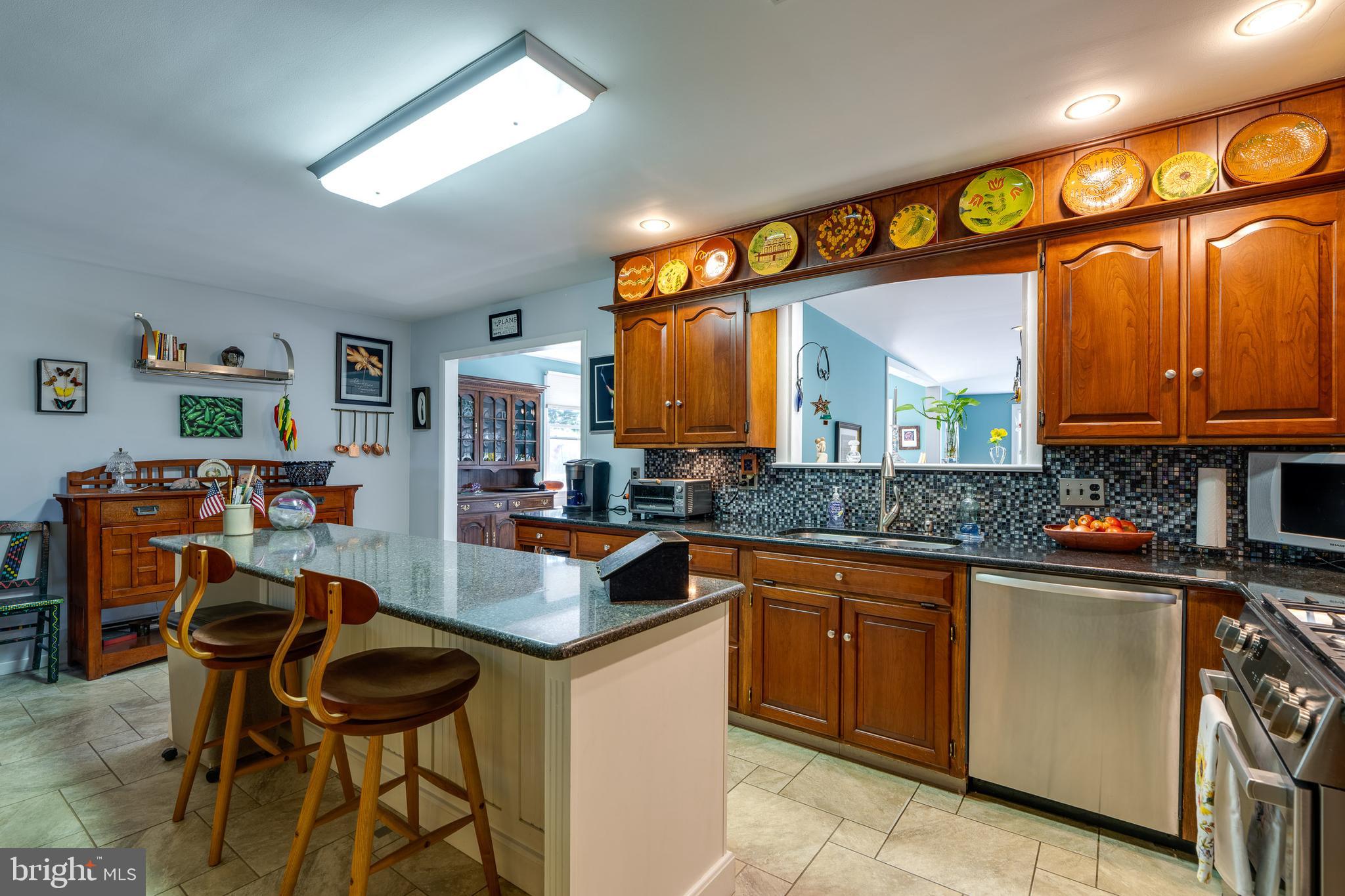 510 Bluebird Road Lititz, PA 17543 - Photo 8 of 32 a kitchen with stainless steel appliances granite countertop wooden cabinets a stove a sink and a dining table