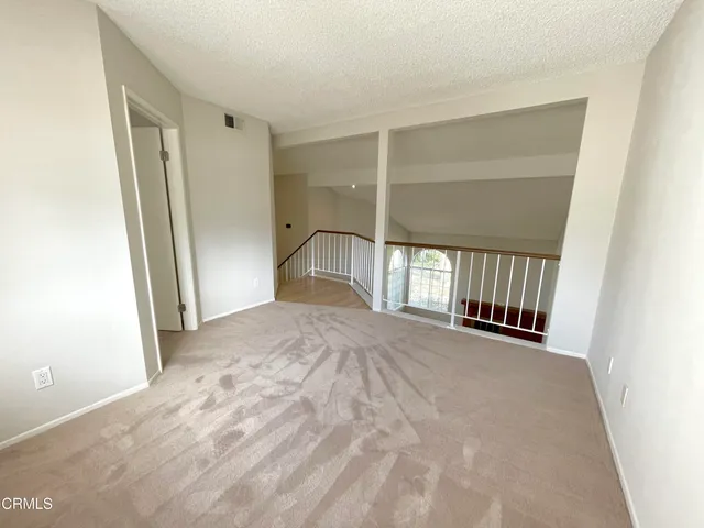 an empty room with windows and stairs
