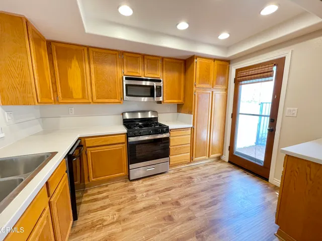 a kitchen with stainless steel appliances a stove top oven a sink and a refrigerator