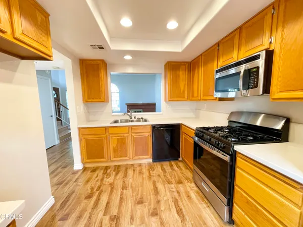 a kitchen with stainless steel appliances a stove a sink and a refrigerator