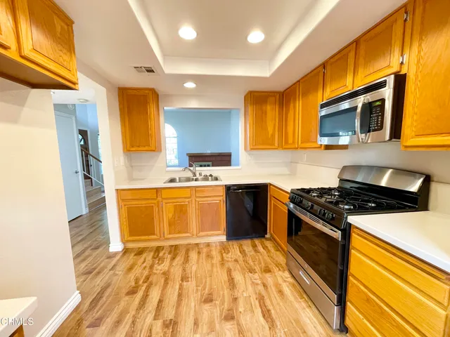 a kitchen with stainless steel appliances a stove a sink and a refrigerator