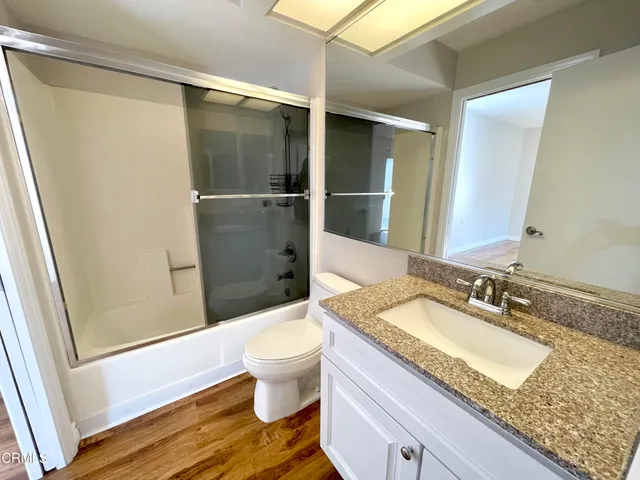 a bathroom with a granite countertop sink toilet and shower