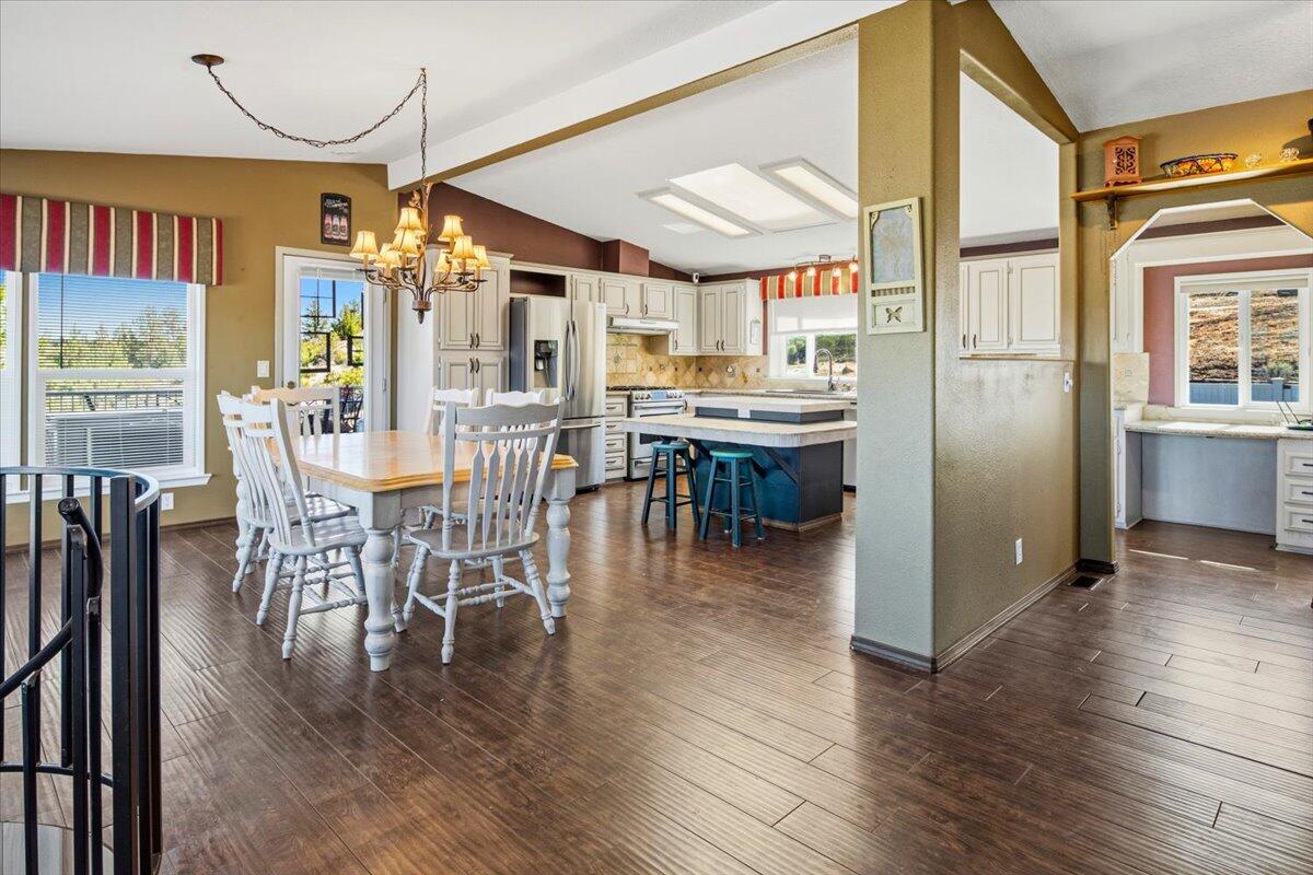 11182 Southwest Dynamite Lane Culver, OR 97734 - Photo 29 of 70 a dining room with wooden floor a chandelier a glass table and chairs