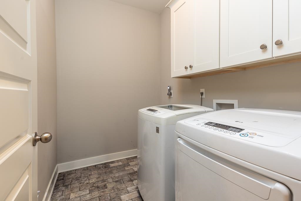 328 Washington Street Collierville, TN 38017 - Photo 27 of 33 Laundry area featuring white cabinetry with brushed nickel hardware, light neutral wall paint, and stone-look tile flooring