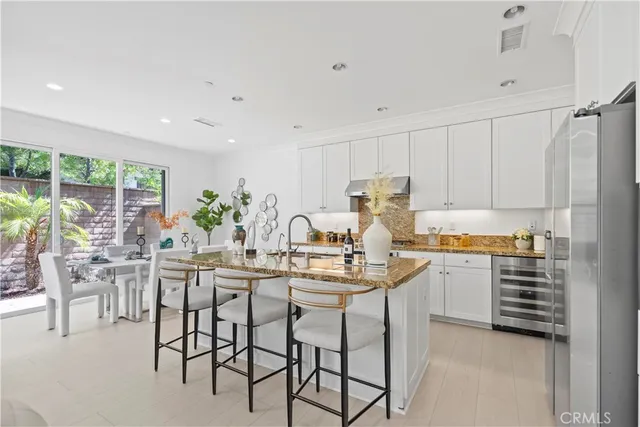 a kitchen with granite countertop white cabinets and white stainless steel appliances