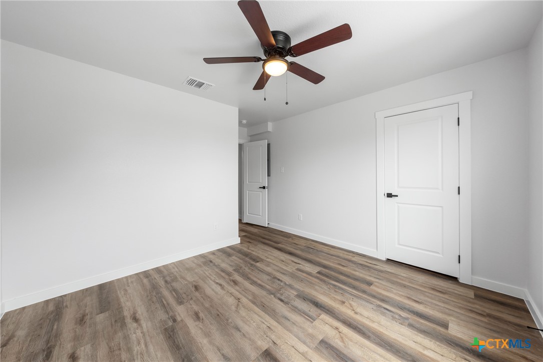820 South 24th Street, Unit A Temple, TX 76501 - Photo 16 of 25 an empty room with wooden floor and a ceiling fan