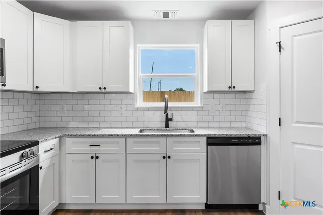 a kitchen with white cabinets and white appliances