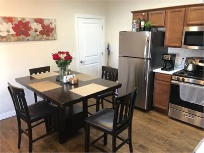 a kitchen with a dining table and refrigerator