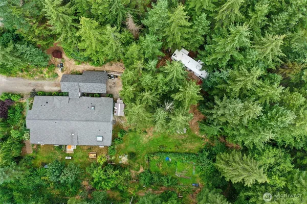 an aerial view of residential house with outdoor space and trees all around
