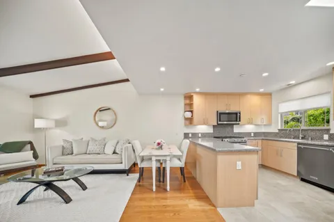 a living room with furniture a rug and white appliances