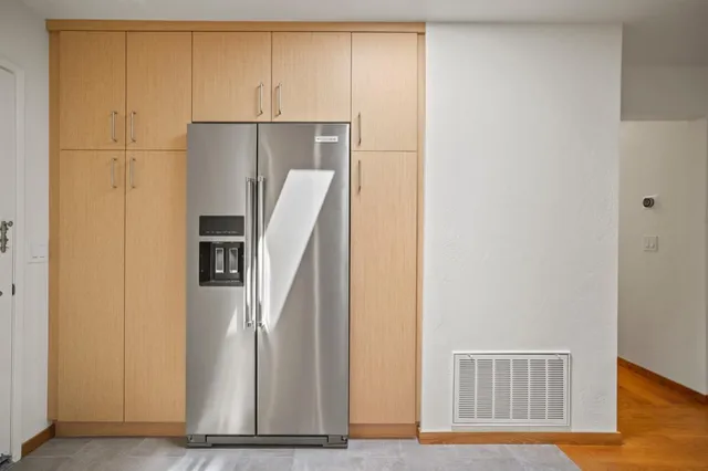a view of a kitchen with refrigerator and wooden floor