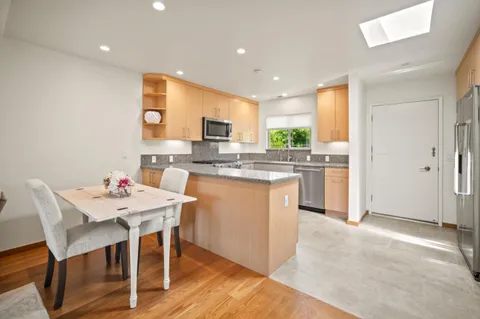 a kitchen with kitchen island a stove a table and chairs