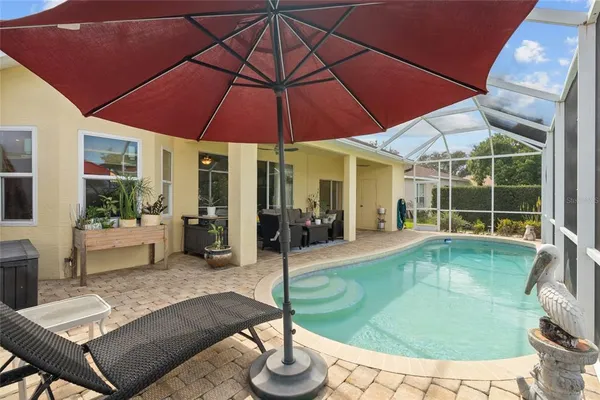 a view of a backyard with swimming pool and sitting area