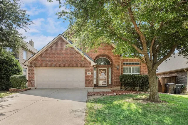 a front view of a house with a garden and trees