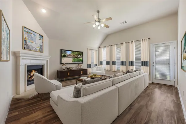 a large living room with furniture a fireplace and a flat screen tv