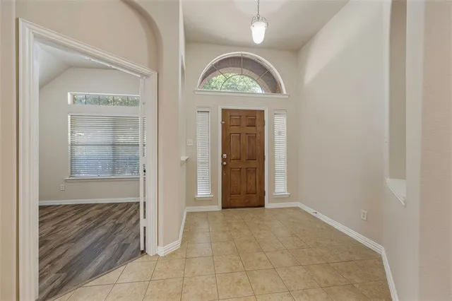an empty room with cabinet mirror and windows