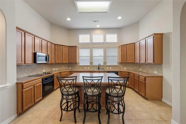 a kitchen with a table chairs sink and cabinets