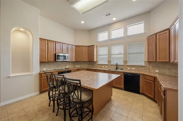 a kitchen with a table chairs sink and cabinets