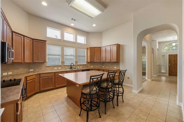 a kitchen with stainless steel appliances granite countertop table chairs sink and window