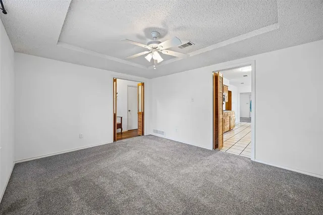 an empty room with closet and a ceiling fan