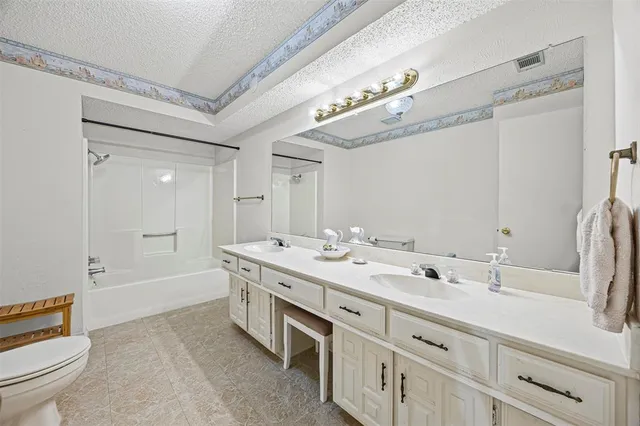 a spacious bathroom with a double vanity sink a mirror and a bathtub