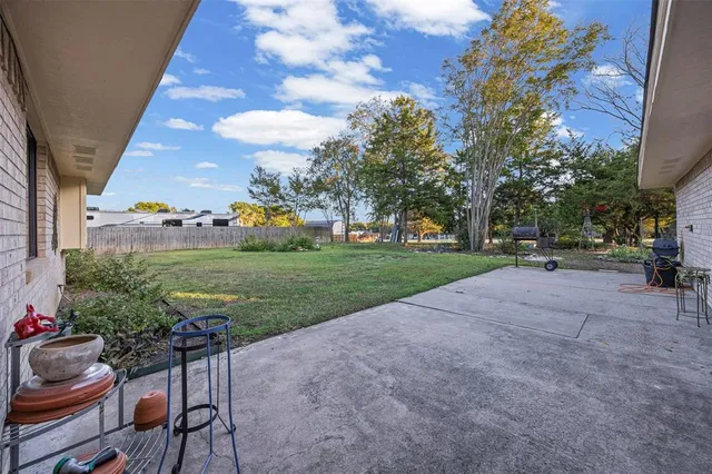 a view of a house with a yard and large tree