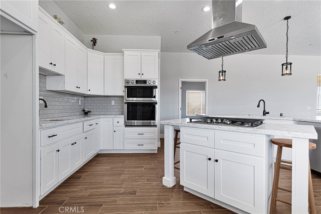 10055 Eaby Road Phelan, CA 92371 - Photo 8 of 19 a kitchen with white cabinets and appliances