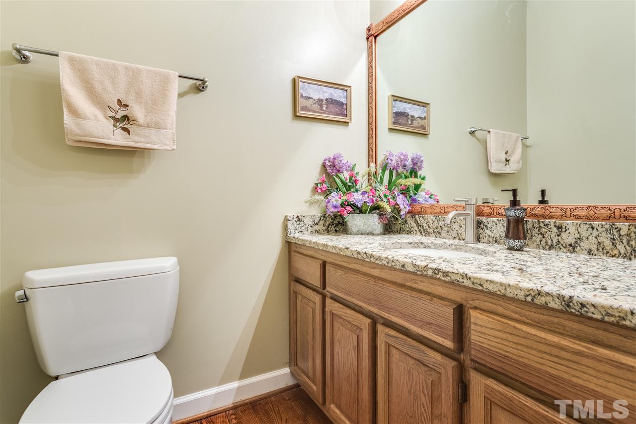 8108 Mourning Dove Road Raleigh, NC 27615 - Photo 17 of 25 a bathroom with a toilet sink and mirror
