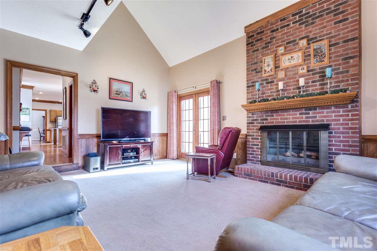 8108 Mourning Dove Road Raleigh, NC 27615 - Photo 18 of 25 a living room with furniture a fireplace and a flat screen tv