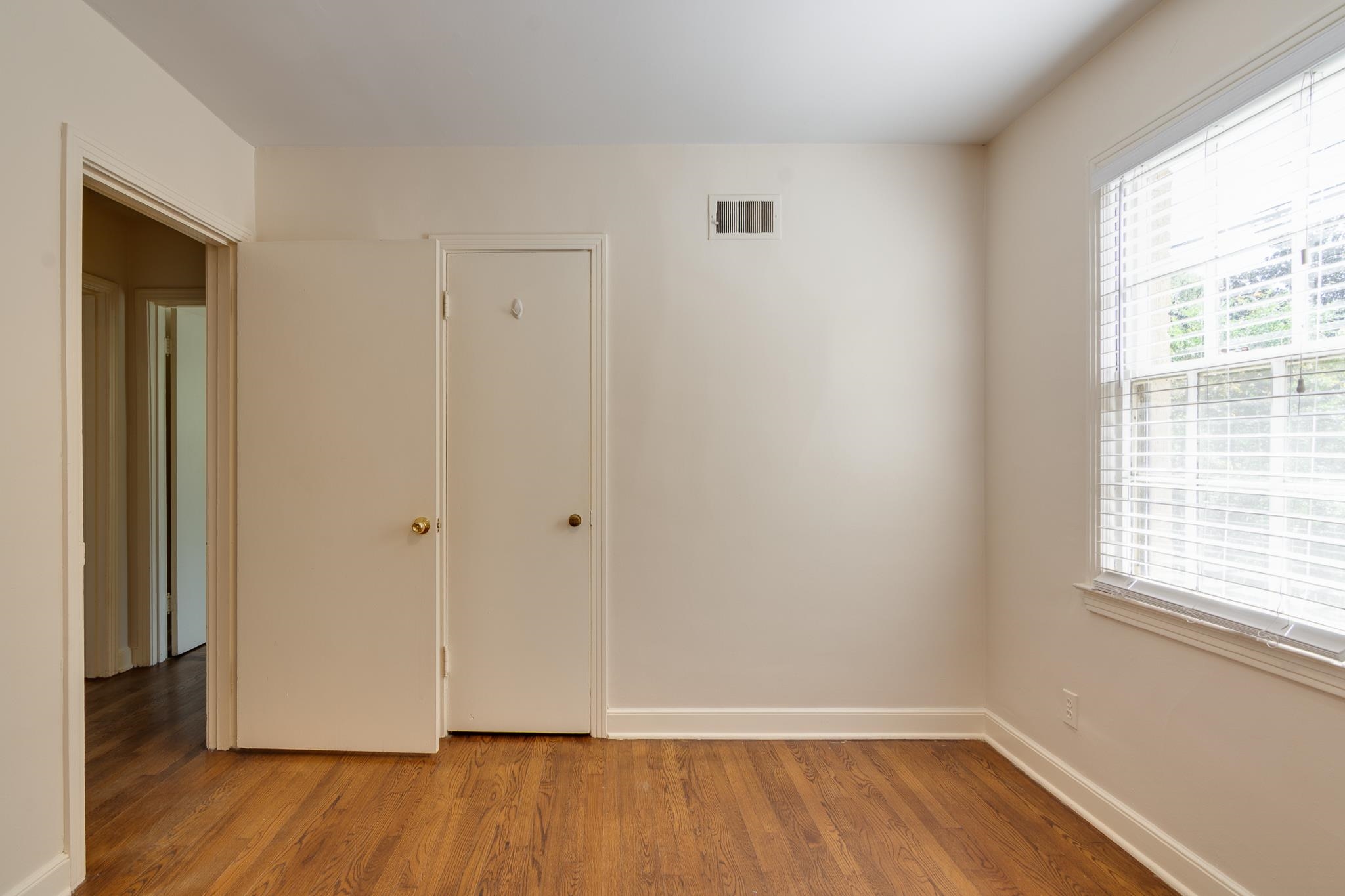 695 Berry Road Memphis, TN 38117 - Photo 19 of 32 a view of an empty room with wooden floor and a window
