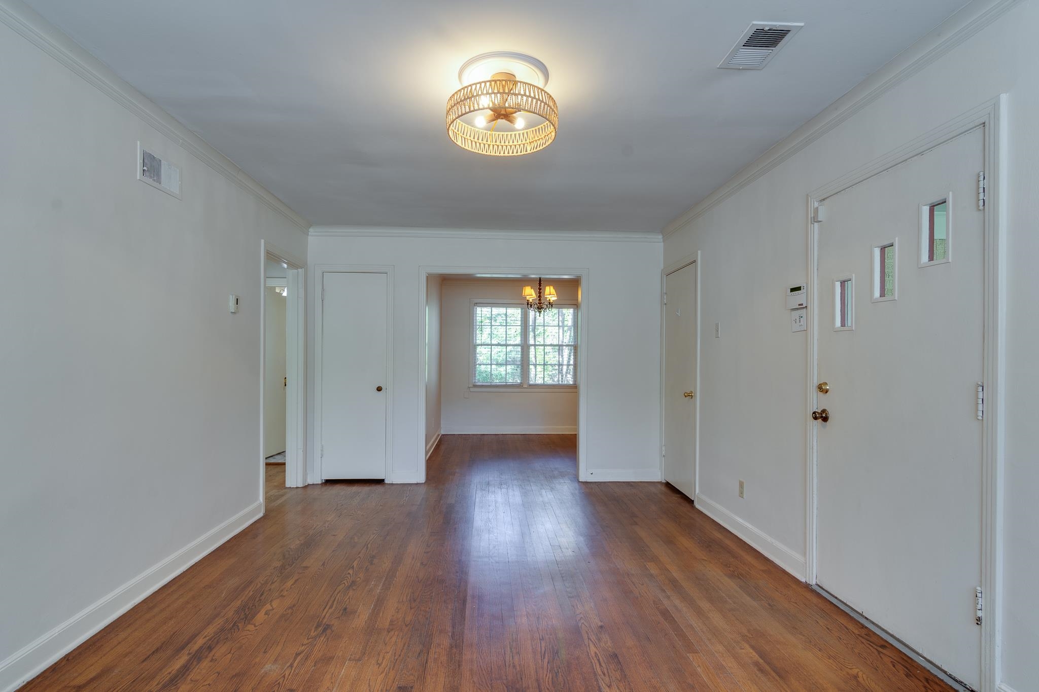 695 Berry Road Memphis, TN 38117 - Photo 3 of 32 a view of an empty room with wooden floor and a window