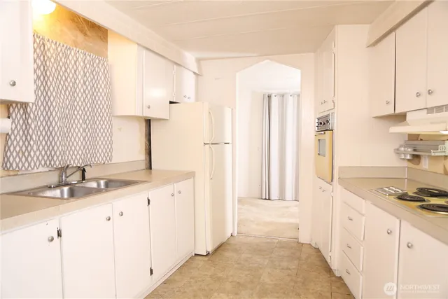 a kitchen with granite countertop a sink stove and cabinets
